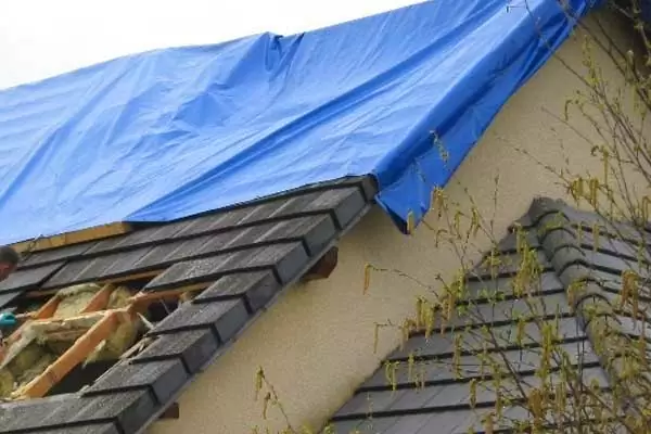 Bâche posée sur une toiture endommagée