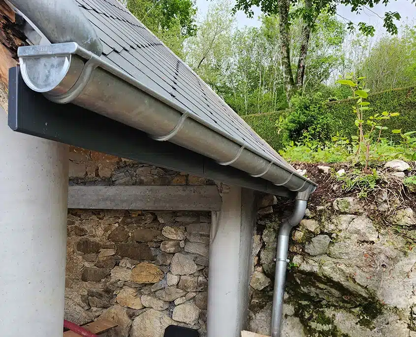 Gouttière demi-ronde en zinc sur une toiture en ardoise