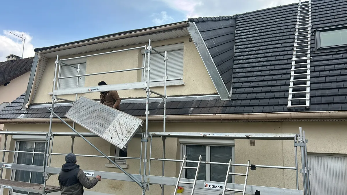 Chantier de toiture avec gouttières et habillages en zinc autour d’une lucarne