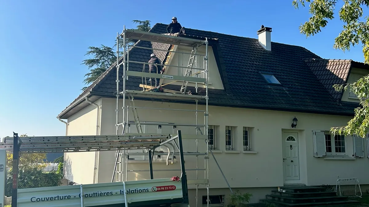 Rénovation d’une toiture en tuiles avec couvreurs et échafaudage devant une maison